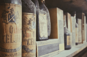 Vintage wine bottles covered in dust, showcasing their age and historical significance.